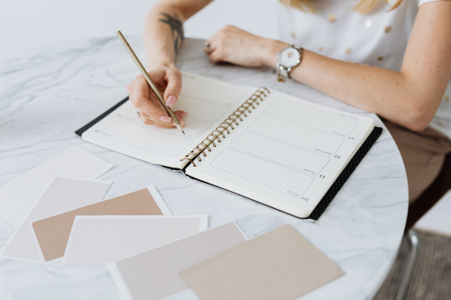 Woman writing plans in a printed weekly planner notebook